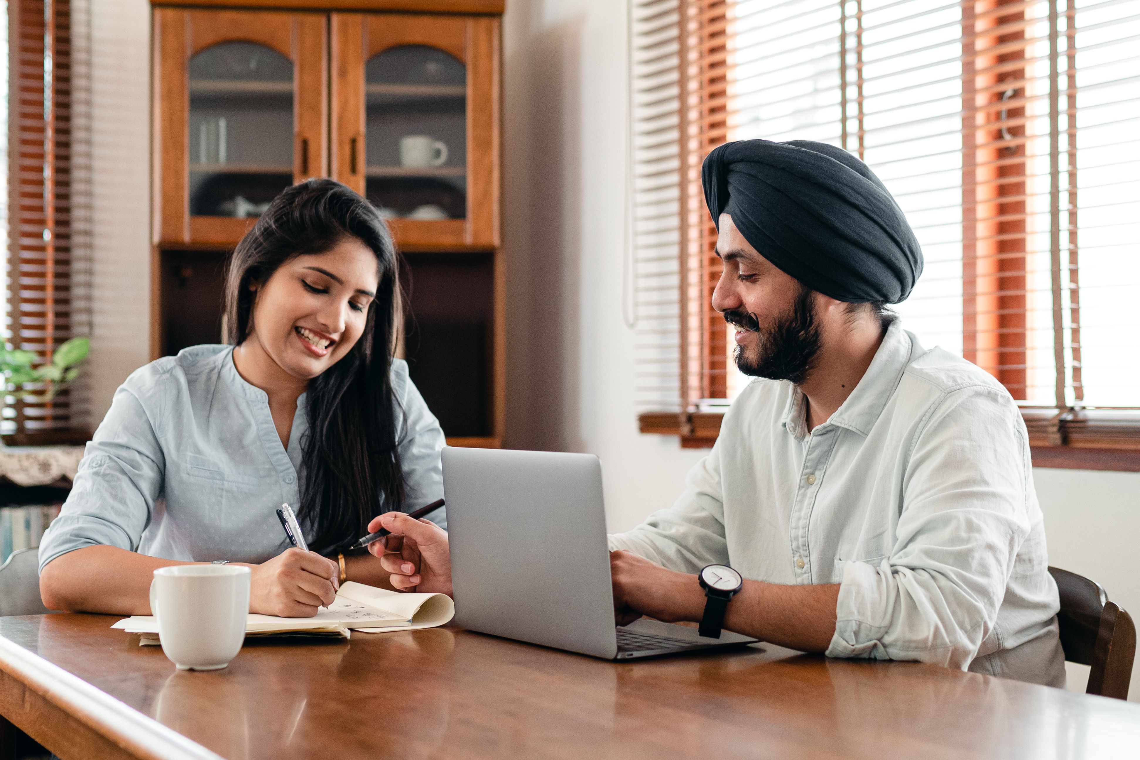 Young Indian professionals discussing work on laptop in office
